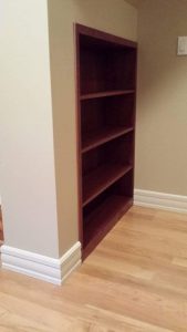 Custom Rolling Book Case that covers underneath stairs storage room